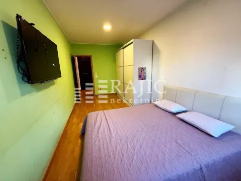 Bedroom with a double bed, wardrobe, and wall-mounted TV. - image 4