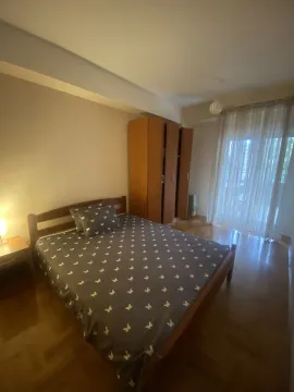 Bright bedroom with a double bed and a wooden wardrobe. - image 16