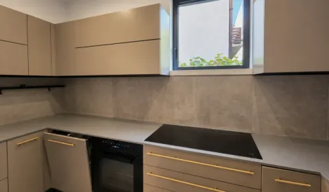 Modern kitchen with built-in oven, cooktop, and beige wall cabinets. - image 7