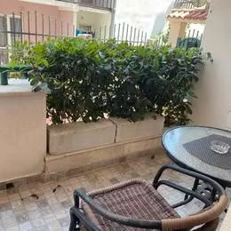 Furnished terrace with a table, chairs, and a green hedge. - image 7