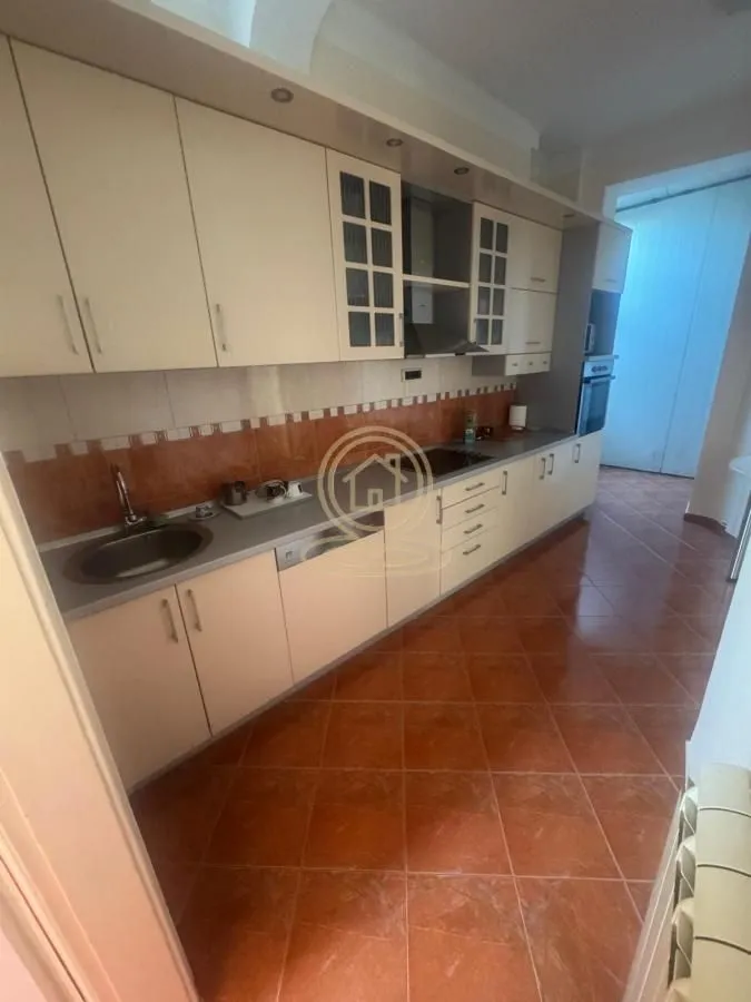 Kitchen with light cabinets and ceramic tiles on the floor and walls.