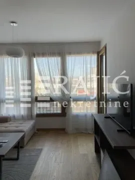 Living room with a sofa and large windows letting in plenty of light. - image 4