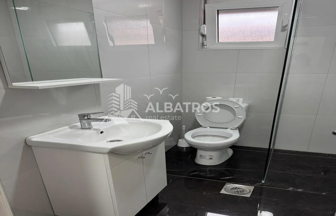 Smaller bathroom with a sink, mirror, and toilet.