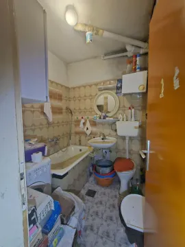 Starije kupatilo sa kadom, umivaonikom, šoljom i mašinom za veš. - image 5
