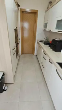 Manja kuhinja sa bijelim elementima i drvenim vratima. - image 4