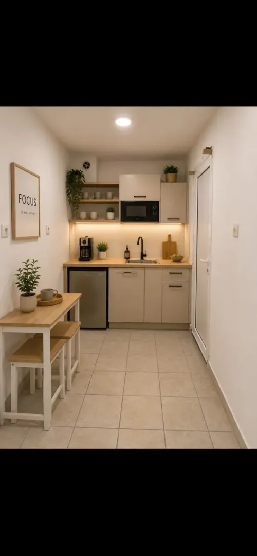 Small kitchen with beige cabinets and a small dining table with two chairs.