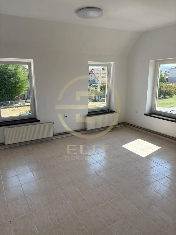 Empty room with ceramic floor tiles and three windows.