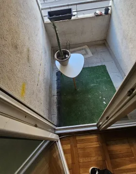 Manji namješten balkon sa vještačkom travom i stolom sa saksijom. - image 13