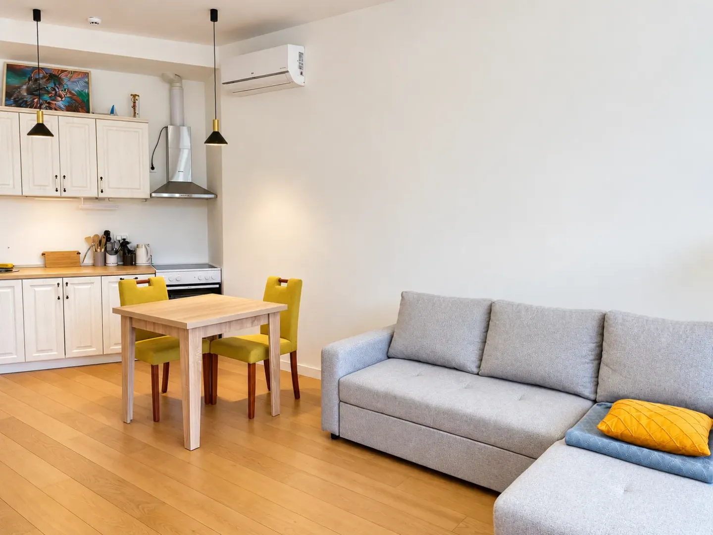 Living room with a dining area and kitchen in bright tones.