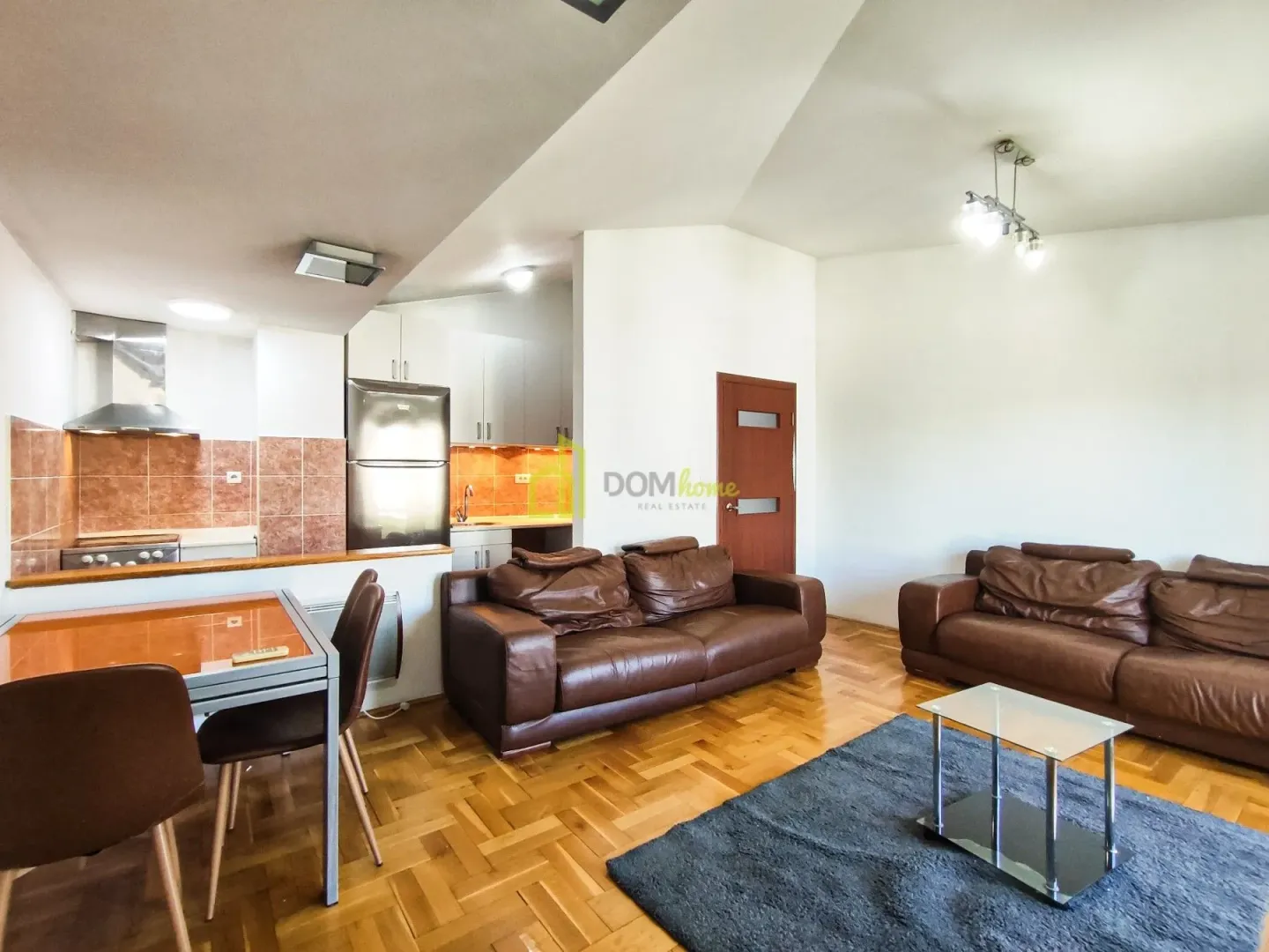 Living room with a dining area and part of the kitchen in the background.