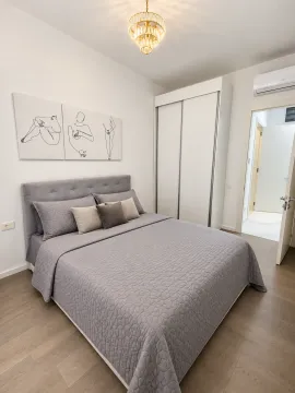 Modern bedroom with a double bed, wardrobe, and wall art. - image 4