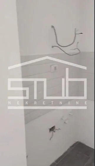 Prikaz dela prostorije u izgradnji sa keramičkim pločicama i instalacijama.