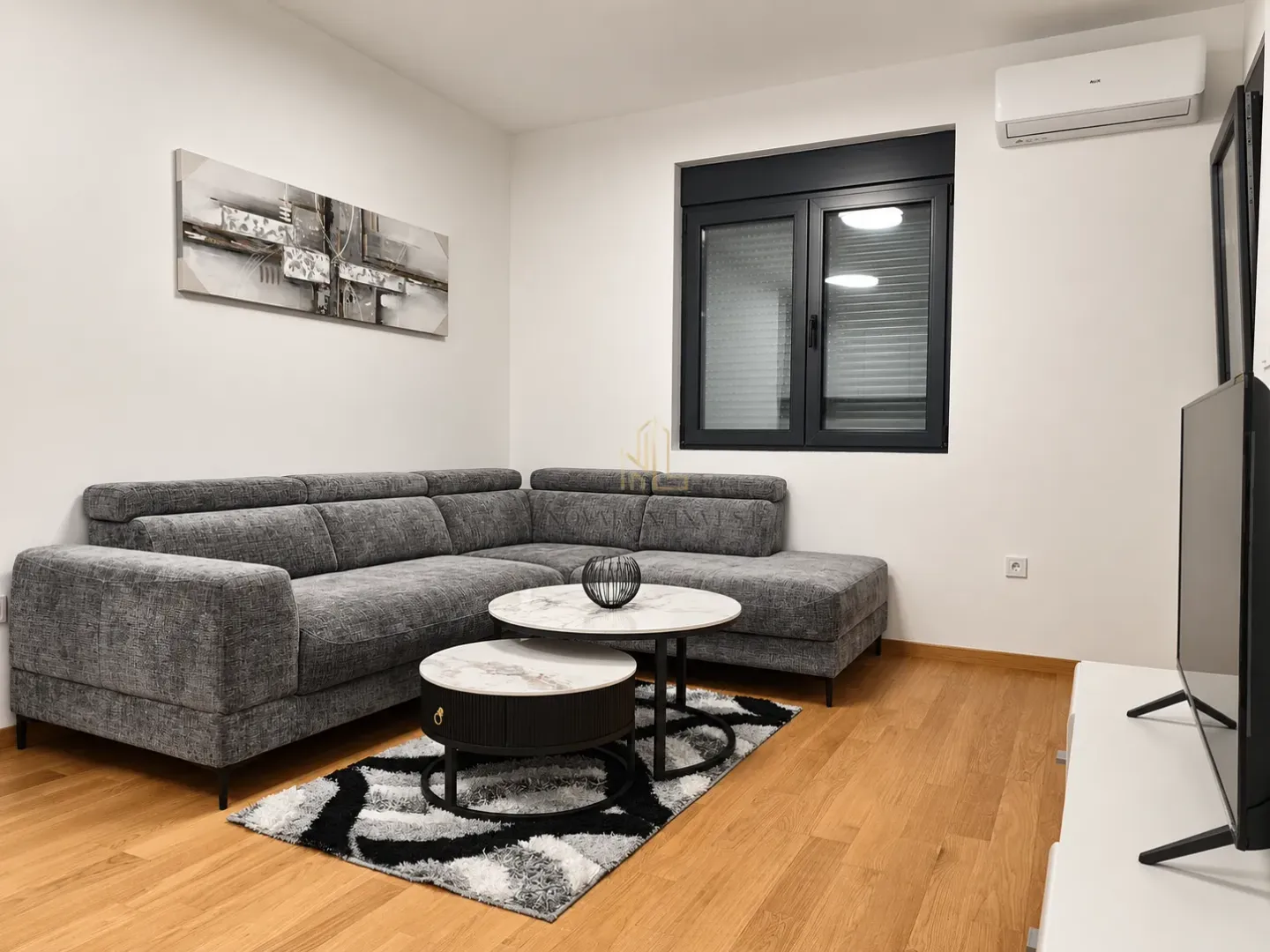 Living room with a gray sectional sofa, coffee table, and television.