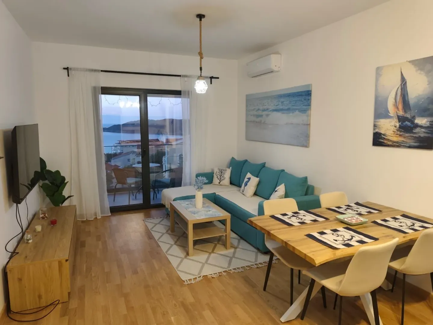Living room with dining area and access to a terrace with a sea view.