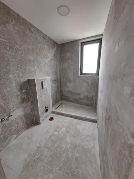 Nedovršeno kupatilo sa sivim pločicama i prostorom za tuš kabinu. - image 12