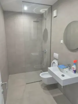 Savremeno opremljeno kupatilo sa tuš kabinom i pločicama u sivoj boji. - image 3