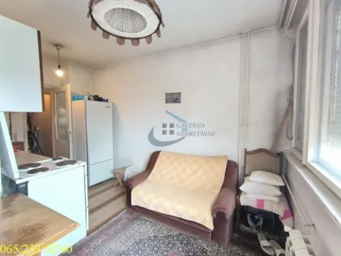 Manja dnevna soba sa garniturom i frižiderom u uglu. - image 12