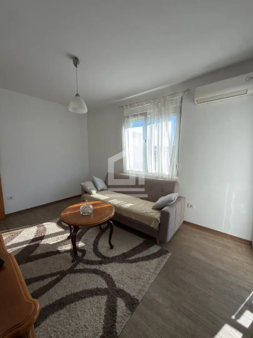 Living room with a sofa, coffee table, and rug.