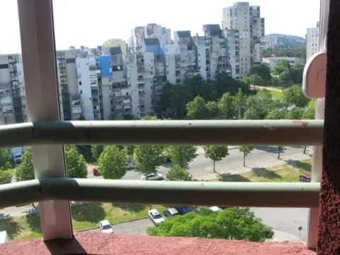 View from the balcony overlooking the street and nearby buildings. - image 12