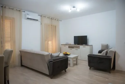 Namještena dnevna soba sa garniturom za sjedenje, televizorom i trpezarijskim stolom. - image 5