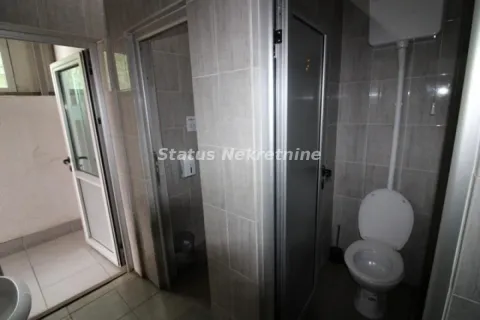 View of a tiled bathroom with a toilet and doors leading to another room. - image 17