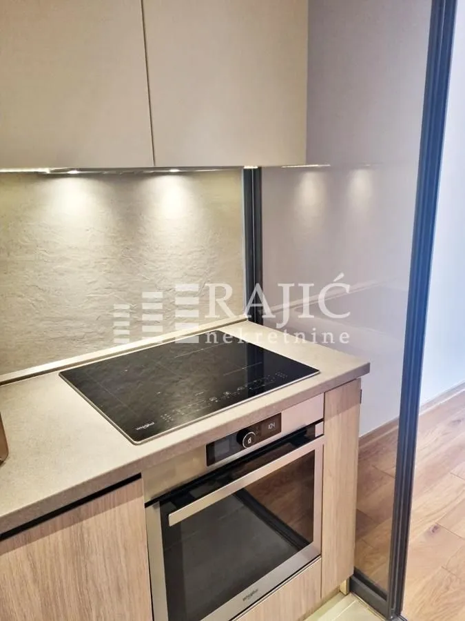 Modern kitchen with built-in oven and cooktop.
