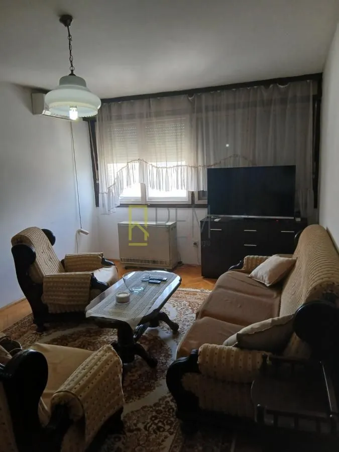 Living room with seating furniture, coffee table, and television.
