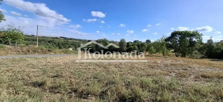 Pogled na otvoreni plac i okolni pejzaž sa zelenilom.