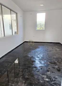 Empty unfurnished room with white walls and dark floor tiles. - image 3
