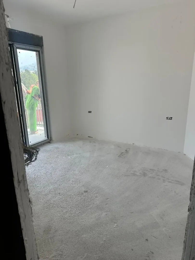 Prazna prostorija u stanju u izgradnji sa balkonskim vratima.