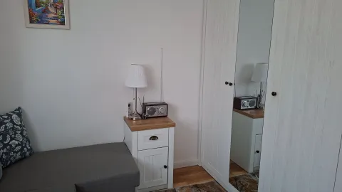 Manja spavaća soba sa krevetom, bijelim ormarom i noćnim stočićem. - image 5