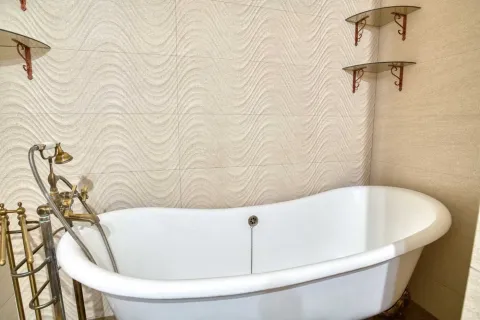 Bathroom with a freestanding bathtub and retro faucets. - image 10