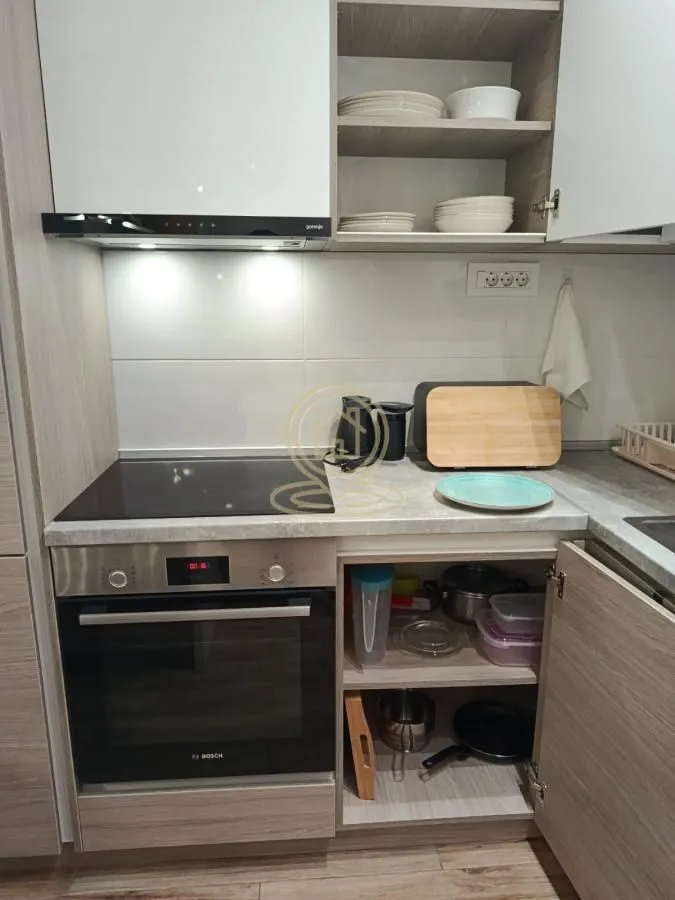 Part of the kitchen with a built-in oven, hob, and cabinets.