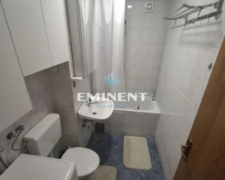 Manje kupatilo sa kadom, umivaonikom, wc šoljom i belim elementima. - image 9