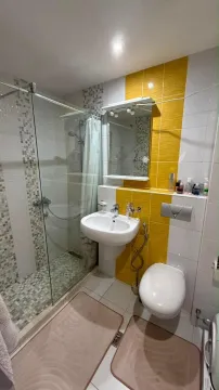 Manje kupatilo sa tuš kabinom i žutim keramičkim pločicama. - image 10