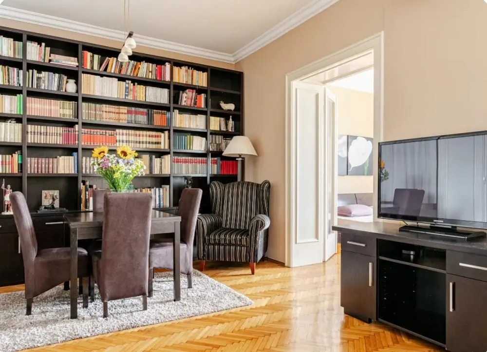 Living room with a large bookcase, dining table, and TV.