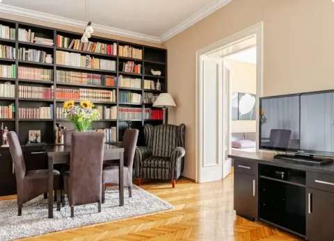 Living room with a large bookcase, dining table, and TV. - image 17