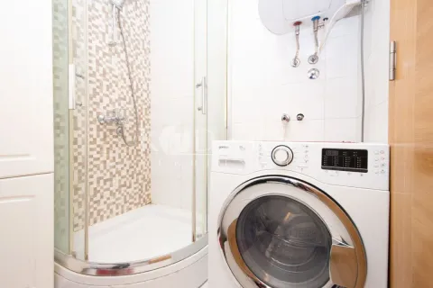 Bathroom with a shower cabin and a washing machine. - image 10