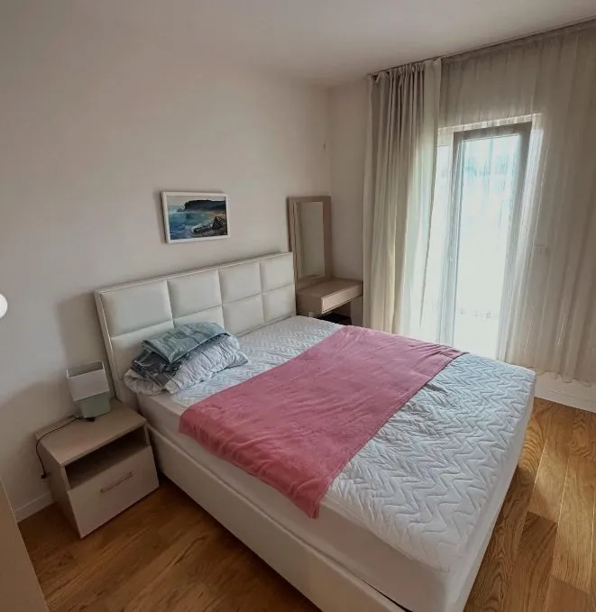 Bright bedroom with a double bed, nightstand, and access to the terrace.