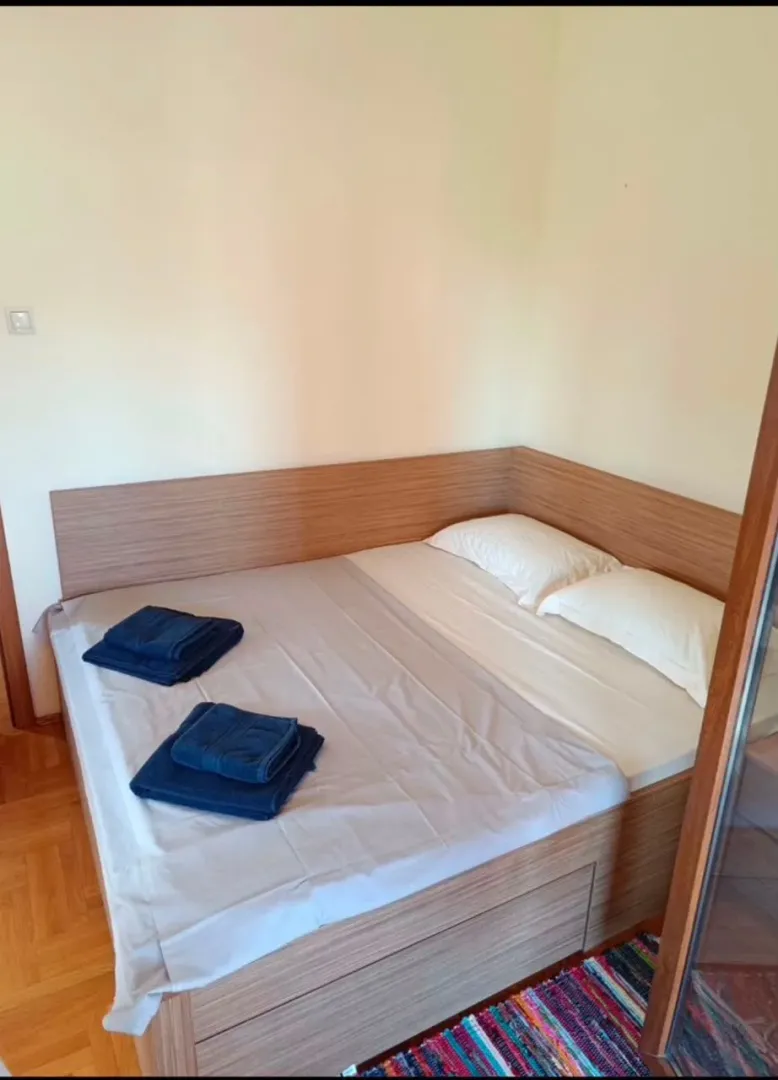 Krevet sa drvenim uzglavljem i posteljinom u spavaćoj sobi.