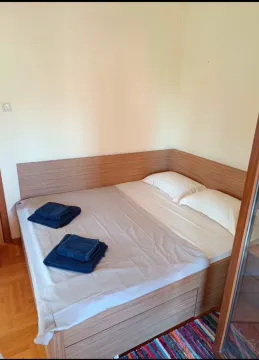 Krevet sa drvenim uzglavljem i posteljinom u spavaćoj sobi. - image 9