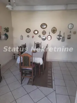 Trpezarija sa drvenim stolom i stolicama, sa ukrasnim tanjirima i ogledalima na zidu. - image 4