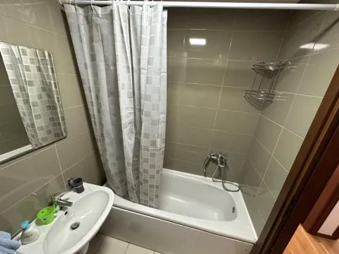 Kupatilo opremljeno kadom, umivaonikom i pločicama u neutralnim tonovima. - image 15
