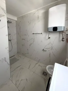 Kupatilo obloženo keramičkim pločicama sa tuš kabinom, wc šoljom i bojlerom. - image 5