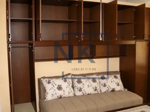 Living room with a sofa and built-in wooden cabinets. - image 4