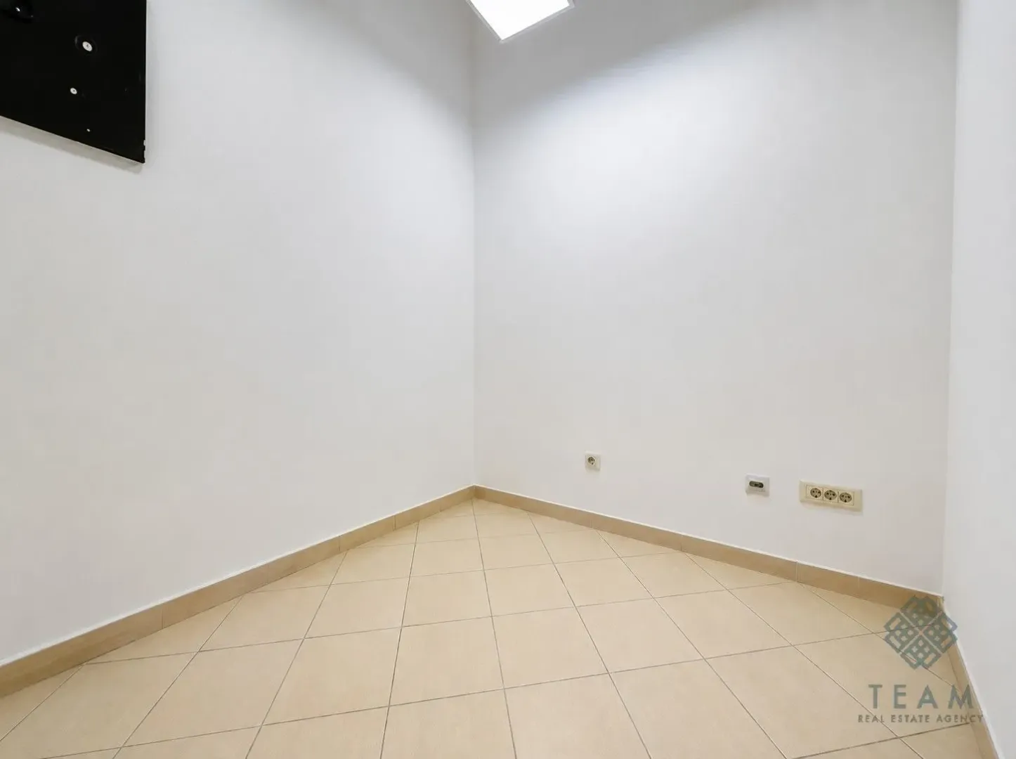 Empty room with white walls and ceramic tile flooring.