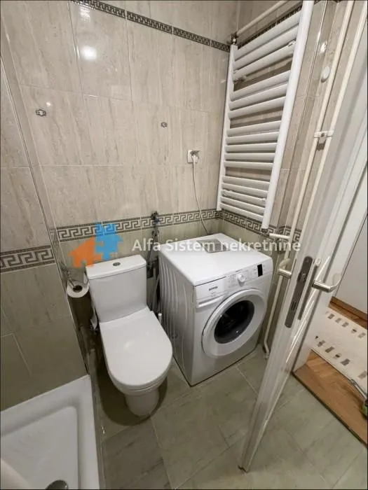 Kupatilo opremljeno sanitarijama, tuš kabinom i veš mašinom.