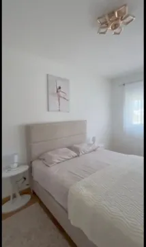 Uređena spavaća soba sa bračnim krevetom i bijelim zidovima. - image 6