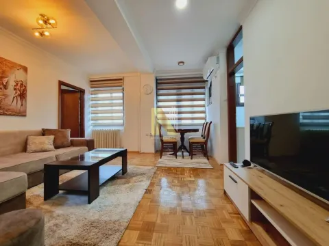 Dnevna soba sa garniturom, stočićem, televizorom i trpezarijskim stolom kod prozora. - image 3
