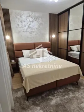 Furnished bedroom with a double bed and a built-in wardrobe with a mirror. - image 17